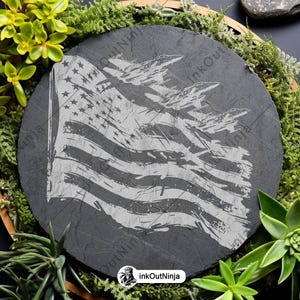May include: A black slate coaster with a distressed white American flag design. The flag is slightly faded and has a grunge aesthetic.