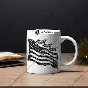 May include: White ceramic mug with a black and white graphic of an American flag with fighter jets flying over it. The text "InkOutNinja" is printed on the mug.