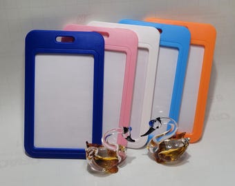 Puede incluir: Cinco portagajetas de plástico en diferentes colores: azul, rosa, blanco, azul claro y naranja. Los portagajetas tienen una ventana de plástico transparente para insertar una tarjeta de identificación o un gafete. Los portagajetas están dispuestos en una fila de izquierda a derecha, con el portagajetas azul a la izquierda y el portagajetas naranja a la derecha.