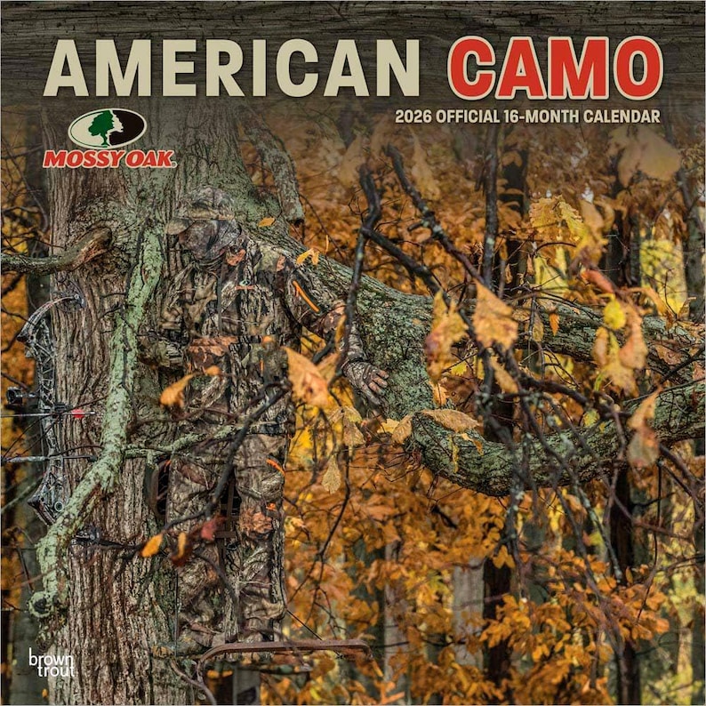 May include: A 2026 official 16-month calendar titled "American Camo" featuring a person in camouflage clothing in a forest setting. The calendar includes the Mossy Oak logo and is published by BrownTrout.