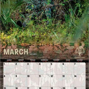 May include: A 2026 calendar featuring a camouflage-clad person in a forest setting, leaning against a tree. The calendar grid for March is visible, with the Mossy Oak logo at the bottom. The image has a natural, outdoor theme.