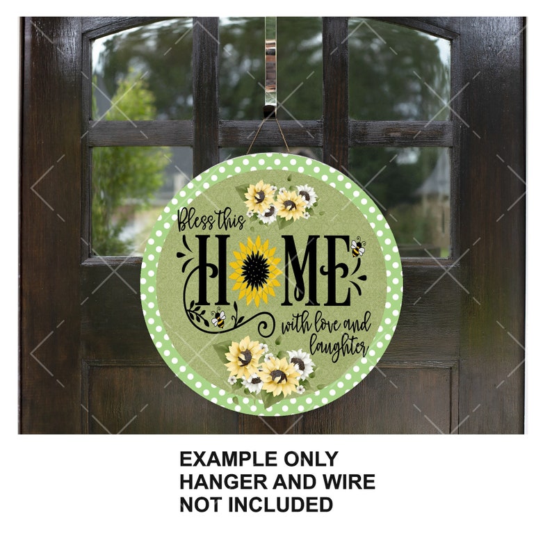 K&ouml;nnte beinhalten: Rundes Holzschild mit gr&uuml;nem Hintergrund und wei&szlig;en Punkten. Das Schild zeigt ein Sonnenblumendesign mit den Worten "Bless this home with love and laughter".