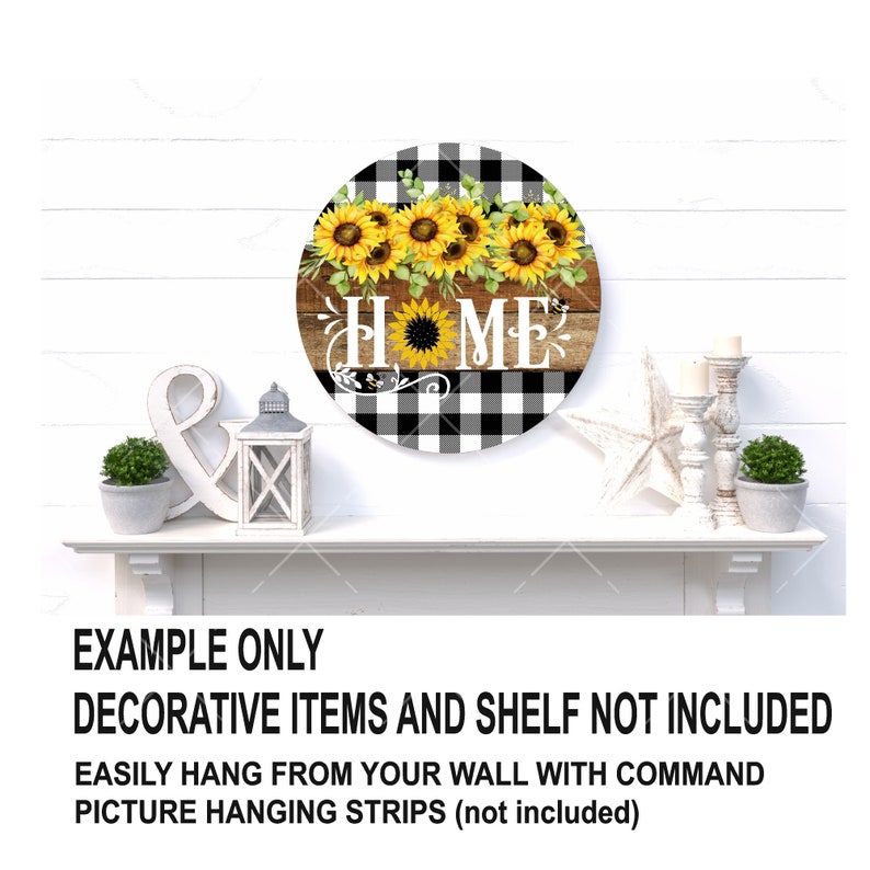 K&ouml;nnte beinhalten: Ein rundes Holzschild mit einem schwarz-wei&szlig; karierten Hintergrund. Das Wort "HOME" ist in Schwarz mit einer Sonnenblume im "O" geschrieben. Eine Reihe von Sonnenblumen mit gr&uuml;nen Bl&auml;ttern befindet sich &uuml;ber dem Wort "HOME".
