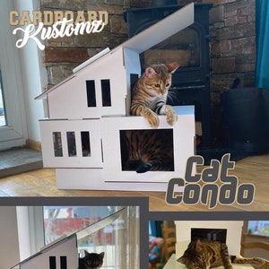 May include: A white cardboard cat condo with multiple levels and openings. A brown tabby cat is sitting on the top level, looking out of the condo. The condo is labeled "cat condo" in black text.