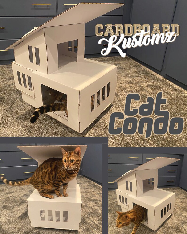 May include: A cardboard cat condo with a white exterior and multiple openings. The condo has a roof that can be lifted. The condo is labeled "Cardboard Kustomz Cat Condo". A brown tabby cat is sitting on the top level of the condo.
