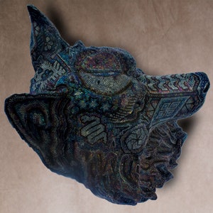 Detailed beaded wolf head sculpture featuring intricate patterns in vibrant shades of blue, green, and purple. The wolf’s striking green eyes create a captivating focal point. Handcrafted with glass seed beads, this textured and dimensional piece brings depth and brilliance to any space. Perfect as wall decor, this Huichol (Wixárika)-inspired artwork blends Mexican folk art, spiritual symbolism, and artisan craftsmanship—ideal for collectors and lovers of unique handmade decor.