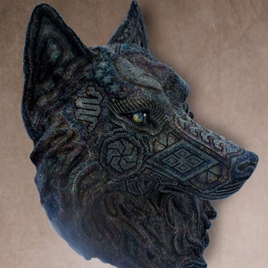 Detailed beaded wolf head sculpture featuring intricate patterns in vibrant shades of blue, green, and purple. The wolf’s striking green eyes create a captivating focal point. Handcrafted with glass seed beads, this textured and dimensional piece brings depth and brilliance to any space. Perfect as wall decor, this Huichol (Wixárika)-inspired artwork blends Mexican folk art, spiritual symbolism, and artisan craftsmanship—ideal for collectors and lovers of unique handmade decor.