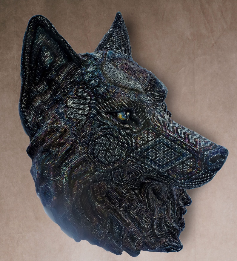 Detailed beaded wolf head sculpture featuring intricate patterns in vibrant shades of blue, green, and purple. The wolf’s striking green eyes create a captivating focal point. Handcrafted with glass seed beads, this textured and dimensional piece brings depth and brilliance to any space. Perfect as wall decor, this Huichol (Wixárika)-inspired artwork blends Mexican folk art, spiritual symbolism, and artisan craftsmanship—ideal for collectors and lovers of unique handmade decor.