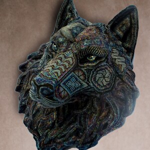 Detailed beaded wolf head sculpture featuring intricate patterns in vibrant shades of blue, green, and purple. The wolf’s striking green eyes create a captivating focal point. Handcrafted with glass seed beads, this textured and dimensional piece brings depth and brilliance to any space. Perfect as wall decor, this Huichol (Wixárika)-inspired artwork blends Mexican folk art, spiritual symbolism, and artisan craftsmanship—ideal for collectors and lovers of unique handmade decor.