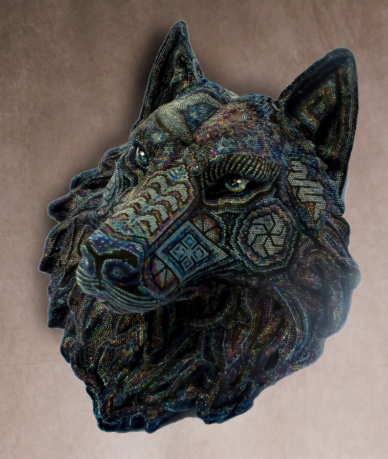 Detailed beaded wolf head sculpture featuring intricate patterns in vibrant shades of blue, green, and purple. The wolf’s striking green eyes create a captivating focal point. Handcrafted with glass seed beads, this textured and dimensional piece brings depth and brilliance to any space. Perfect as wall decor, this Huichol (Wixárika)-inspired artwork blends Mexican folk art, spiritual symbolism, and artisan craftsmanship—ideal for collectors and lovers of unique handmade decor.