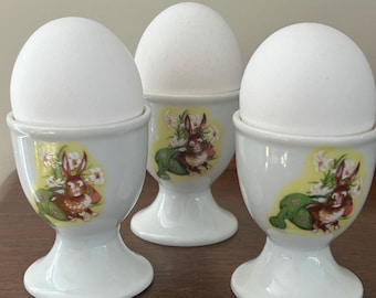 Juego de 3 hueveras con conejitos de Pascua entre flores de primavera, fabricado por Crown Art Ceramics Nagoy, Japón, de segunda mano, en excelentes condiciones de exhibición.