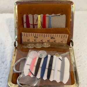 A vintage travelling mending kit enclosed in a leather purse preowned unused old/new c 1960s purse measures 3 3/8 x 2 3/4 - inches compact.