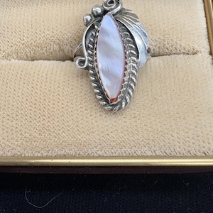 A vintage Navajo 1 inch long elongated silver ring size 5 signed by the artist with the initials JM. The vintage ring in very good condition
