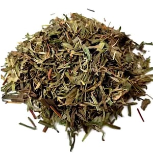Può includere: Primo piano di erbe di dragoncello essiccate, con una miscela di foglie verdi e marroni. Le erbe sono finemente tagliate e appaiono secche, con alcuni steli visibili. Probabilmente per uso culinario.