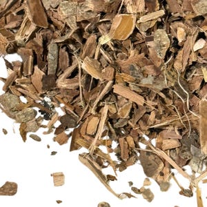 May include: Close-up of a pile of dried, brown bark pieces. The bark fragments vary in size and shape, with a mix of light and dark brown tones. Some pieces have a layered texture, and a few thin, light-colored strands are visible.