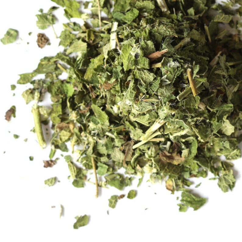 May include: A pile of dried green nettle leaves, a common herb used in teas and tinctures.