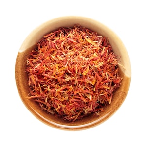 May include: A bowl of dried saffron threads, a vibrant red-orange colour, in a brown ceramic bowl. Saffron is a popular spice used in cooking and is known for its intense flavour and aroma.
