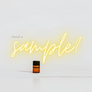 May include: A small amber glass bottle with a black lid, sitting on a white surface. The text "need a sample?" is written in yellow neon lettering.
