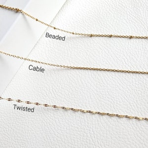 May include: Three gold chains on a white background. The chains are labeled "Beaded", "Cable", and "Twisted".