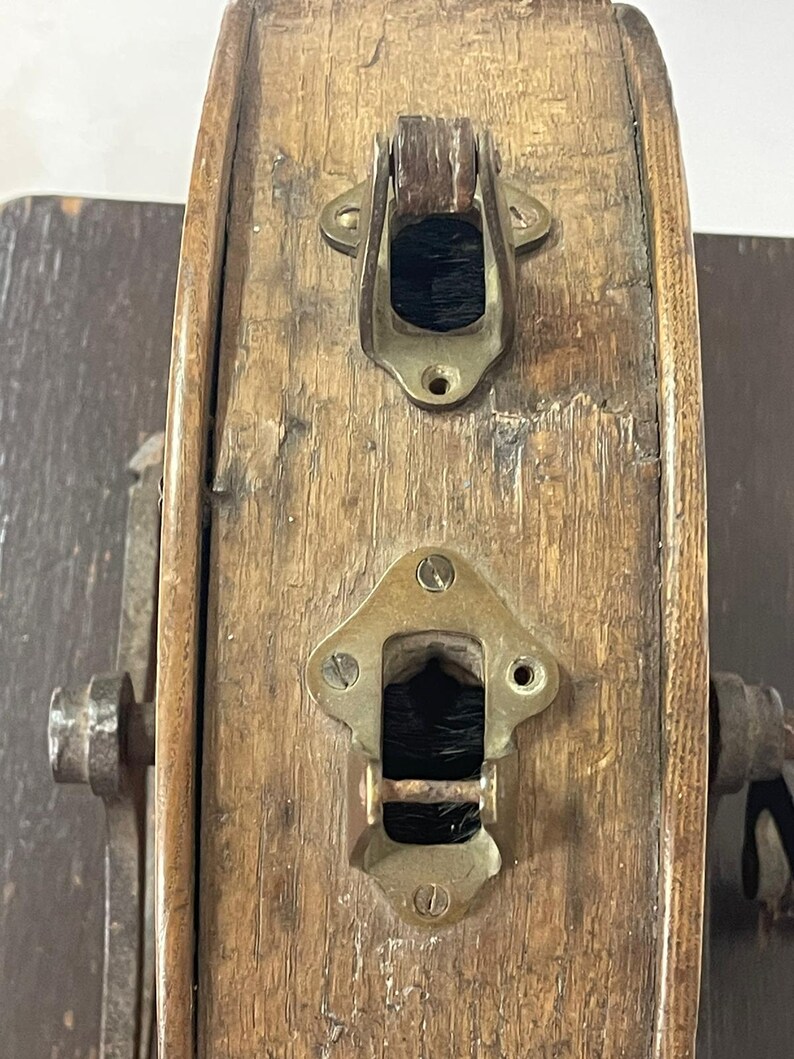 May include: Close-up of a weathered wooden barrel with brass hardware. The barrel features two brass clasps and a keyhole, showcasing an antique aesthetic. The wood has visible grain and signs of age.