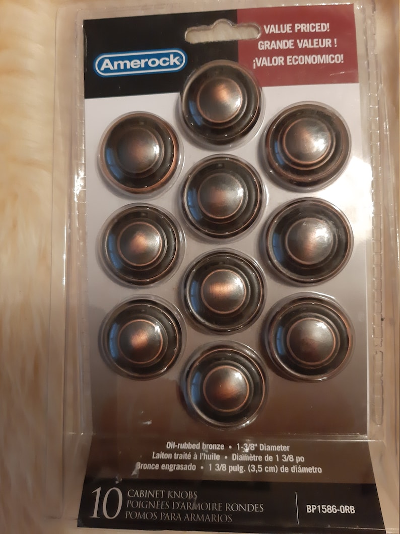 Może przedstawiać: Dziesięć gałek meblowych z brązu olejowanego o średnicy 3,5 cm. Gałki mają koncentryczny wz&oacute;r k&oacute;ł. Opakowanie zawiera kod produktu BP1586-ORB.