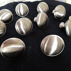 K&ouml;nnte beinhalten: Zehn runde, silberfarbene Schrankkn&ouml;pfe mit glatter, gl&auml;nzender Oberfl&auml;che.