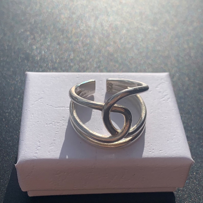 Op de afbeelding: Een zilveren ring met een gedraaid ontwerp. De ring is aan de binnenkant gemarkeerd met het nummer "925".