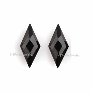 May include: Two black diamond-shaped gemstones with a faceted design.