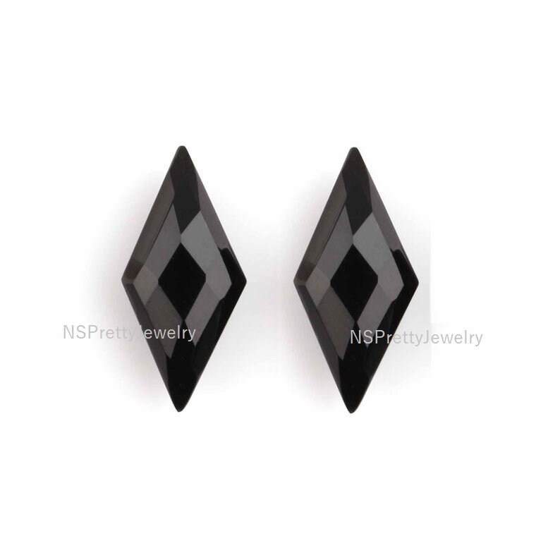 May include: Two black diamond-shaped gemstones with a faceted design.