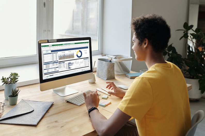 Pu&ograve; includere: Una persona seduta a una scrivania davanti a uno schermo di computer. Lo schermo mostra un foglio di calcolo con grafici e diagrammi. La persona sta usando una tastiera e un mouse per navigare nel foglio di calcolo.