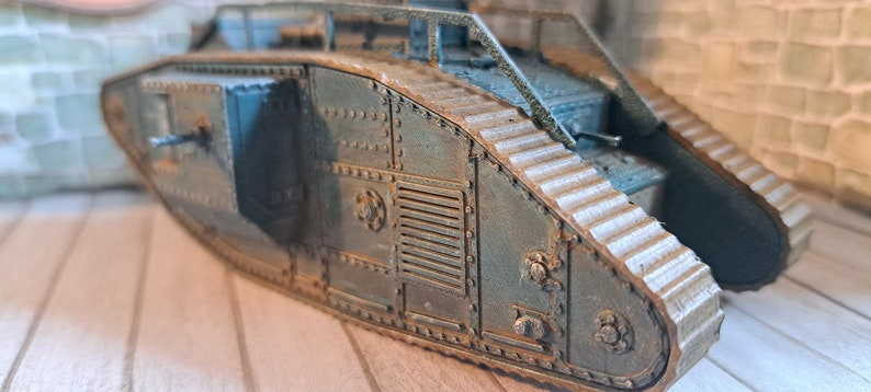 Op de afbeelding: Een close-up van een model van een tank uit de Eerste Wereldoorlog, geschilderd in donkergroen met roestkleurige accenten. De tank heeft een gedetailleerd ontwerp met zichtbare rupsbanden en een grote geschutskoepel.