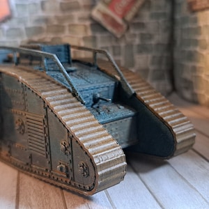 Op de afbeelding: Een bruin en blauw model van een tank uit de Eerste Wereldoorlog met rupsbanden en een verhoogde geschutskoepel.