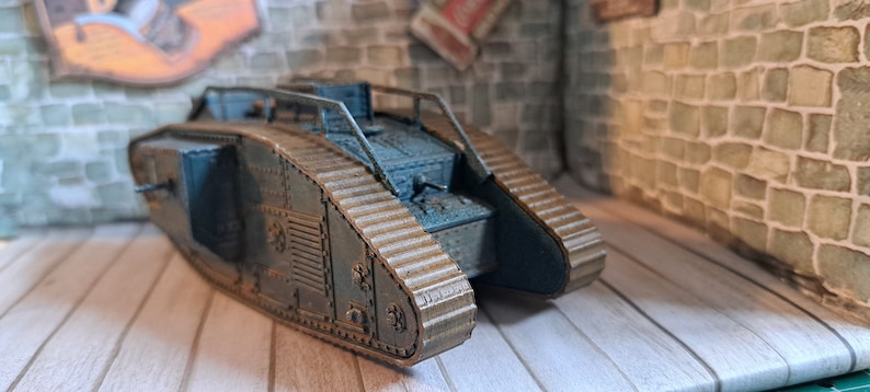 Op de afbeelding: Een bruin en blauw model van een tank uit de Eerste Wereldoorlog met rupsbanden en een verhoogde geschutskoepel.