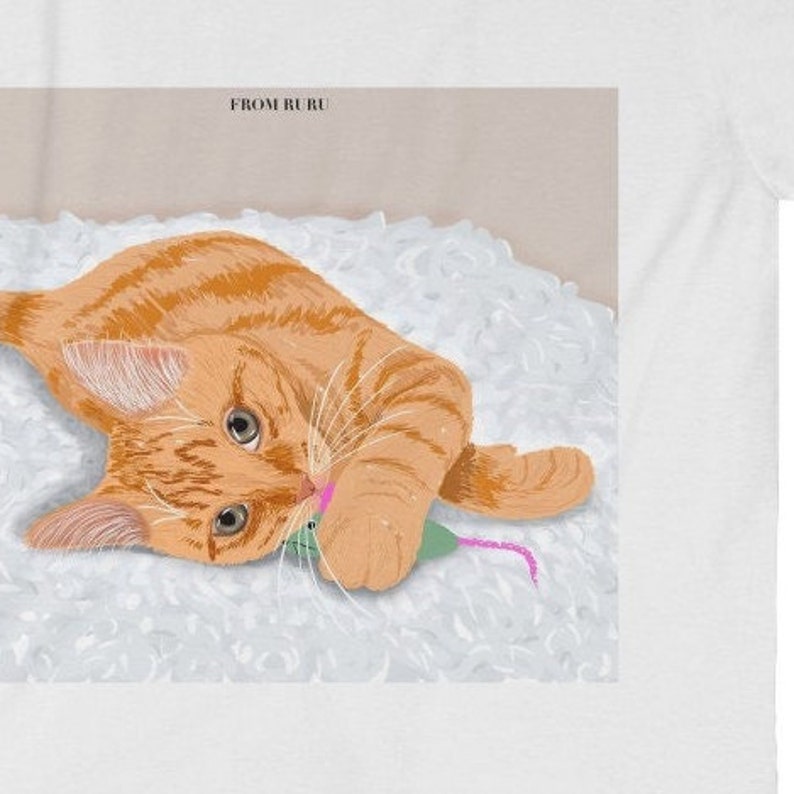 May include: A ginger cat with white paws plays with a pink and green toy mouse on a white fluffy surface. The text "FROM RURU" is in the top left corner of the image.