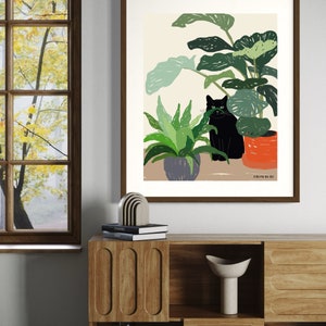 May include: A framed illustration of a black cat sitting in a pot of plants. The plants are green and the pot is orange. The background is a light beige color. The text "FROM RURU" is at the bottom of the illustration.