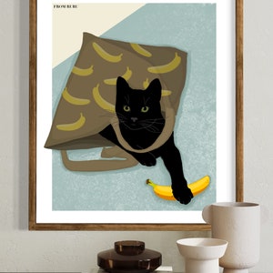 K&ouml;nnte beinhalten: Eine schwarze Katze mit gr&uuml;nen Augen schaut aus einer braunen Tragetasche mit Bananenmuster. Die Katze h&auml;lt eine gelbe Banane in ihrer Pfote. Der Text "FROM RURU" befindet sich in der oberen linken Ecke des Bildes.