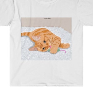 May include: A ginger cat with green eyes lies on a white fluffy surface, playing with a pink and green toy mouse. The text "FROM RURU" is in the top right corner of the image.