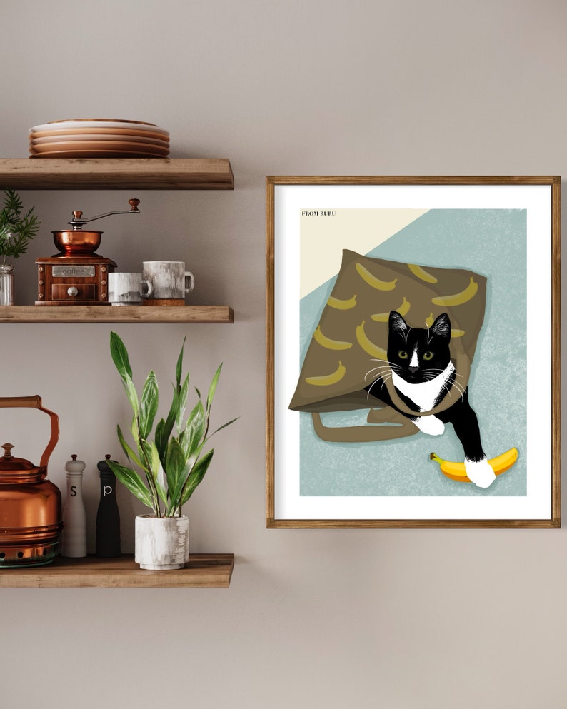 K&ouml;nnte beinhalten: Eine schwarz-wei&szlig;e Katze mit gr&uuml;nen Augen sitzt in einer braunen Tasche mit Bananenmuster. Die Katze h&auml;lt eine gelbe Banane in ihrer Pfote. Das Bild ist mit "From Rue" betitelt.