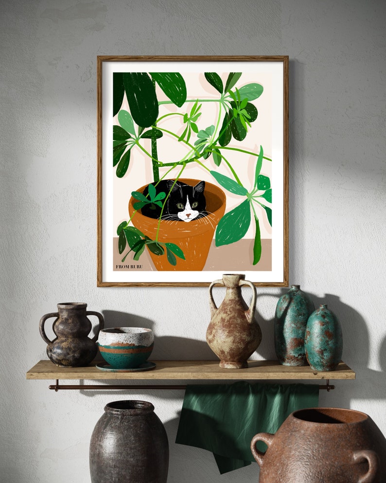Pu&ograve; includere: Un gatto bianco e nero &egrave; rannicchiato in un vaso di piante verdi e frondose. Il gatto guarda direttamente lo spettatore. L'immagine &egrave; incorniciata in una cornice di legno marrone. Il testo "FROM RU RU" &egrave; stampato nell'angolo in basso a sinistra dell'immagine.
