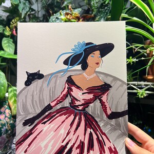 May include: A woman in a pink and red dress with a black hat and blue ribbon sits on a couch with a black cat. The woman has blue eyeshadow and is wearing a pearl necklace. The image is titled "FROM RURU".