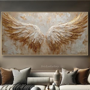 Pode incluir: Uma grande pintura retangular em tela com um par de asas de anjo estilizadas em tons de ouro e branco. A obra de arte tem um estilo texturizado, de empasto, com pinceladas visíveis. A pintura é emoldurada em uma moldura dourada.