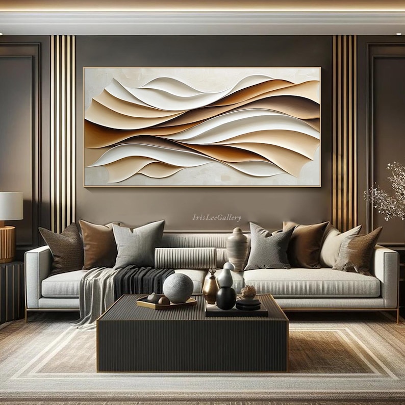 May include: A modern living room interior design with a large abstract painting featuring brown and white wavy lines. The painting is hanging above a white sofa with brown pillows. A coffee table with decorative objects sits in front of the sofa.