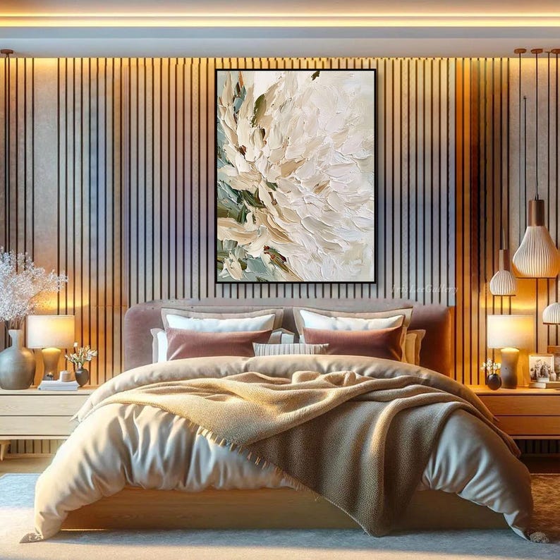 May include: A rectangular wall art piece featuring a thick, textured oil painting of a large white flower with subtle green and beige undertones. The artwork is displayed in a black frame, mounted on a wall with vertical wooden slats and warm lighting.
