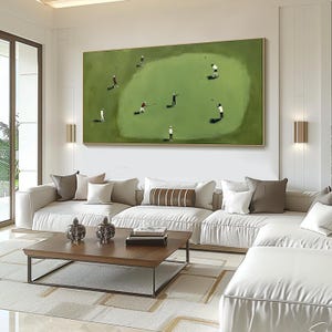 May include: A large rectangular painting depicts a golf course scene with several golfers. The artwork is framed in gold and hangs above a white sectional sofa and a wooden coffee table. The room has a modern design.