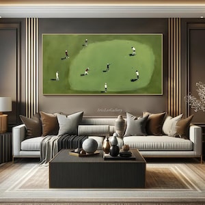 May include: A framed painting depicts a golf course scene with several golfers in action. The artwork features a green golf course with players in white and red attire. The painting is displayed above a modern sofa in a living room setting.