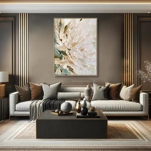 May include: A vertical rectangular canvas painting featuring thick, textured impasto brushstrokes in shades of cream, white, beige, and muted sage green, depicting an abstract floral bloom centered on a dark wall above a sofa.