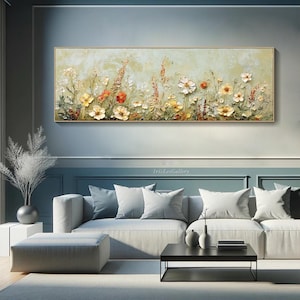 May include: A rectangular floral painting with a gold frame. The artwork features a textured, light green background with a variety of colorful flowers in shades of yellow, orange, and white. The painting is displayed above a gray sofa.