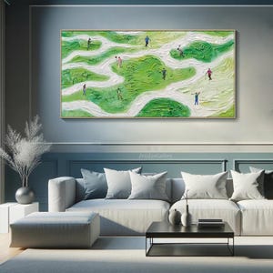 May include: Abstract painting of a golf course with green and white colors. The painting depicts a group of people playing golf on a winding course. The painting is framed and hanging on a wall in a living room setting.