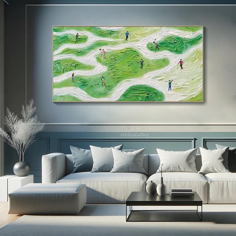 May include: Abstract painting of a golf course with green and white colors. The painting depicts a group of people playing golf on a winding course. The painting is framed and hanging on a wall in a living room setting.