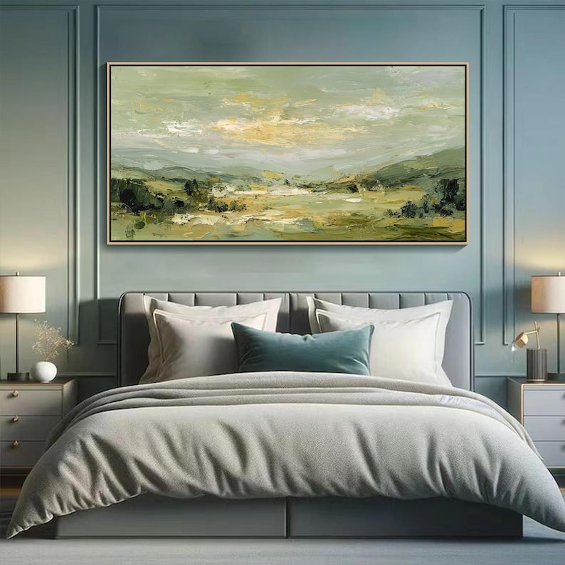 May include: An abstract landscape painting in a gold frame hangs above a bed. The artwork features a palette of greens, yellows, and whites, depicting a serene countryside scene. The bed is made with white pillows, a teal bolster pillow, and a gray comforter.